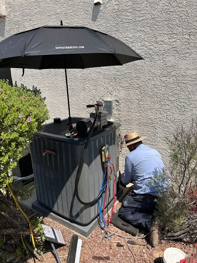 HVAC technician performing outdoor AC maintenance in Glasgow Village