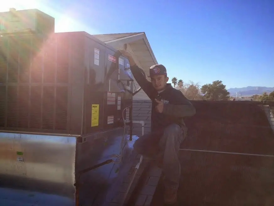 HVAC technician performing Air Duct Cleaning on a rooftop unit in Glasgow Village